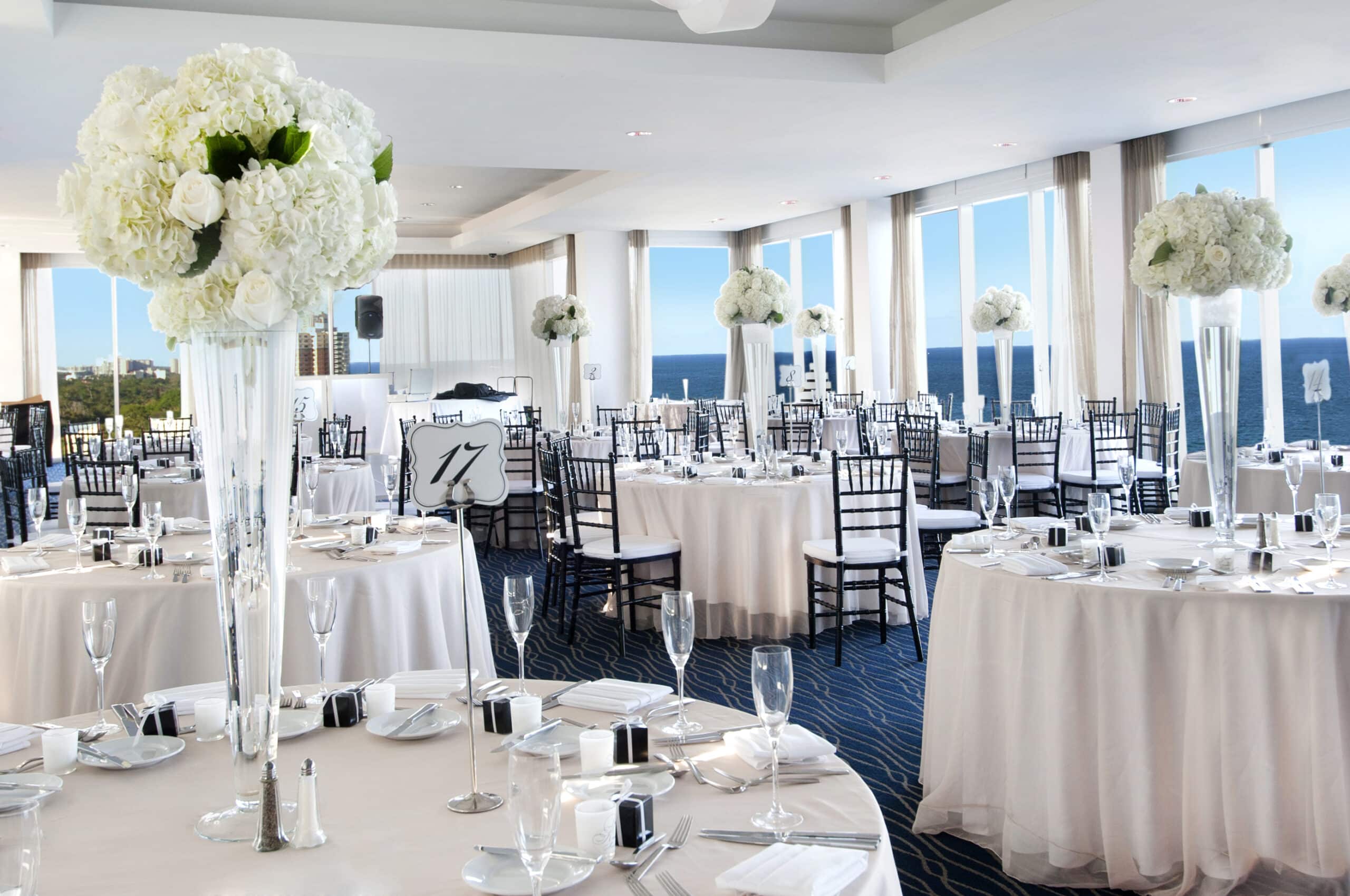 Banquet hall with ocean views and elegant floral decor.