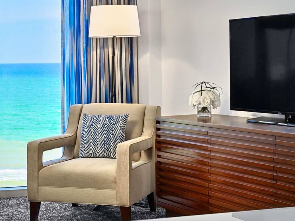 Hotel guestroom seating area, TV and an ocean view.