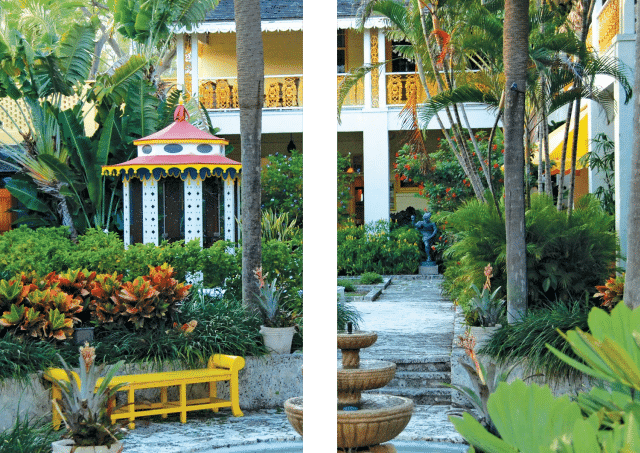 Lush garden courtyard with colorful gazebo and benches.